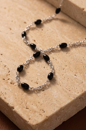 Dusk Chain aus 925 Sterlingsilber mit Onyx-Perlen auf Travertin